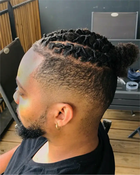 homme avec un dégradé et des dreadlocks tressées du coiffeur barbier Barbe à Papa